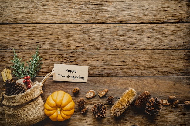 Happy Thanksgiving day background with pumpkin and greeting tag on wood table