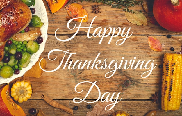 Photo happy thanksgiving lettering on a festive dinner background food table background with autumn season...