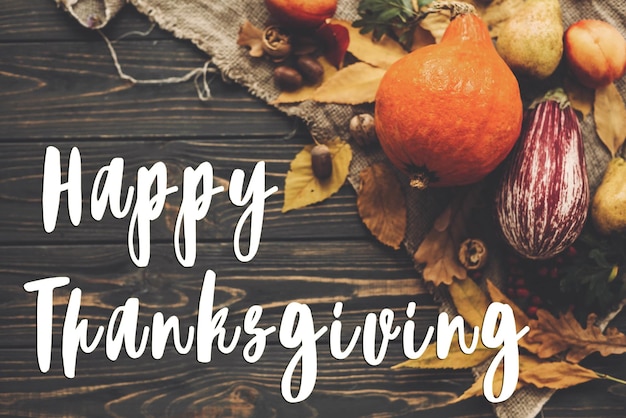 Happy Thanksgiving Text on beautiful composition of Pumpkin autumn vegetables with colorful leavesacornsnuts berries on wooden rustic table Seasons greeting card