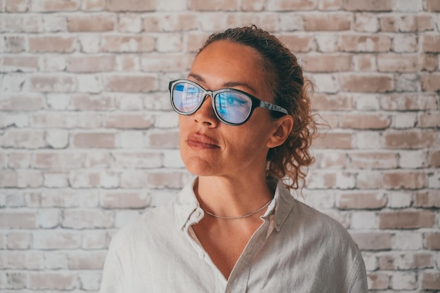 Happy thoughtful millennial business woman in casual looking at window with pensive dreamy smile thinking of work project future vision ambitious career planning goals Head shot portraitxA