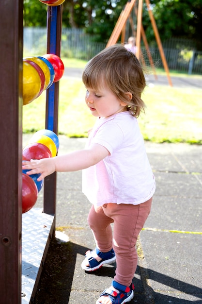 Happy toddler, baby or child on playground area. Playing kid. Education, active games outside.