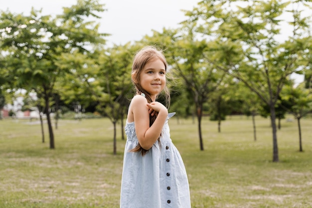 公園で愛らしい子供のポーズと笑顔の幸せな幼児の女の子