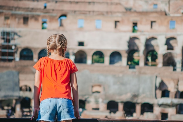 Happy toddler girl in rome over coliseum background