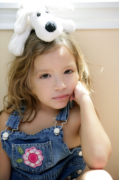 Happy toddler girl with toy dog over head