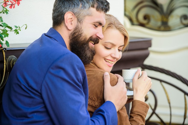 Foto felici insieme coppia che coccola la terrazza del caffè coppia innamorata siediti abbracciati sulla terrazza del caffè goditi il caffè piacevole fine settimana in famiglia esplora bar e luoghi pubblici bella coppia sposata che si rilassa insieme