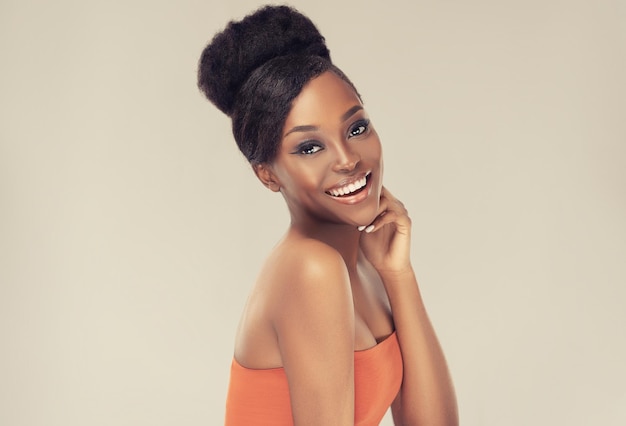 Felice sorriso a trentadue denti sul viso di un modello attraente con un vibrante tono della pelle melaninrich bellezza afro