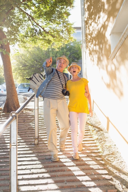 都市で歩く幸せな観光客のカップル