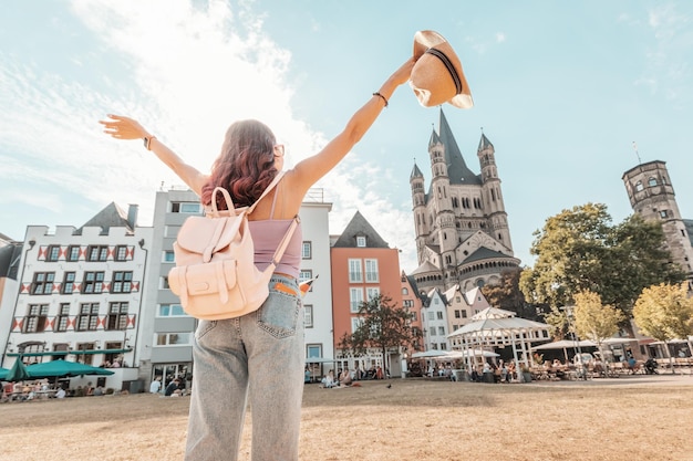 Happy tourist girl walks and enjoys vacations in the old town of Cologne at fish market square Germany travel and sightseeing