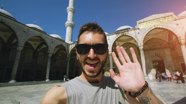 Uomo turistico felice che ha chat video online vicino alla famosa moschea blu di istanbul