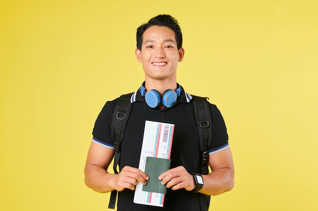 Happy tourist with backpack and plane ticket