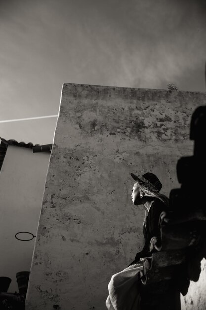 A happy tourist woman wearing black hat overlooks the colorful old town in Portugal