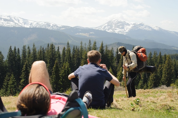 행복한 관광객이 땅에 누워 산 꼭대기에서 경치를 즐기고 있습니다.