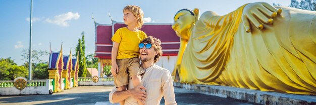 Счастливые туристы папа и сын на фоне длинного формата знамени статуи будды