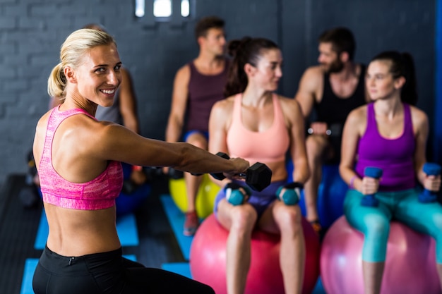 Happy trainer with athletes in gym