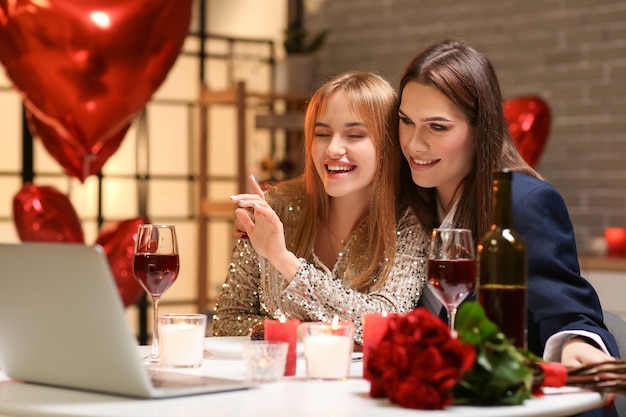 Happy transgender couple video chatting with friends on Valentine's Day at home