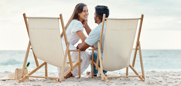 Happy travel and love of a couple from India on a beach ocean and sea vacation Happiness of Indian people smile with a peace relax and calm mindset together by the waves sand and water in nature