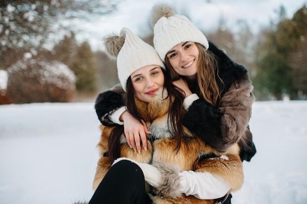 Happy travel together of two fashionable girls in sunny city centre Young joyful women expressing positivity using map vacation with bags camera making photo cheerful emotions great mood