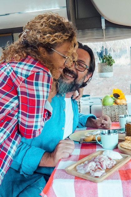 Happy traveler couple hug with love and fun together inside a camper van motor home People using rv vehicle for travel and enjoy holiday vacation on the road Van life off grid lifestyle caucasian