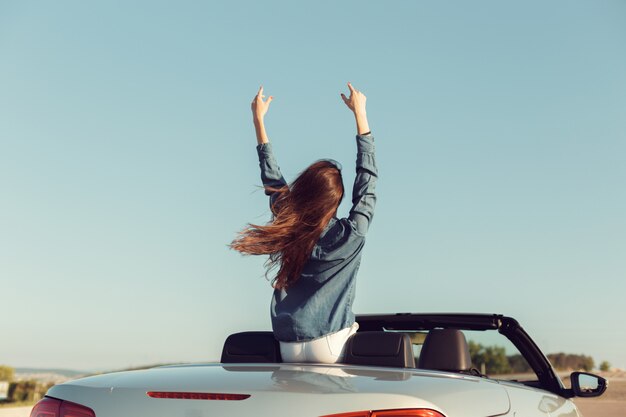 Happy traveler woman in cabrio car