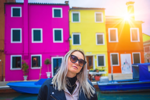 Donna felice del viaggiatore che si diverte vicino a case colorate sull'isola di burano nel viaggio della laguna veneziana e