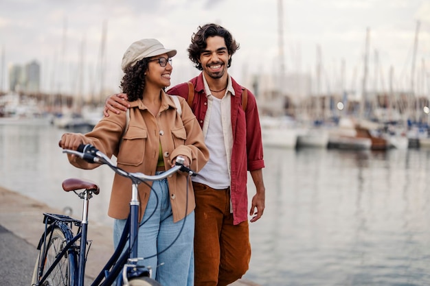 A happy travelers with bike are hugging and walking on the dock in their visit to Spain