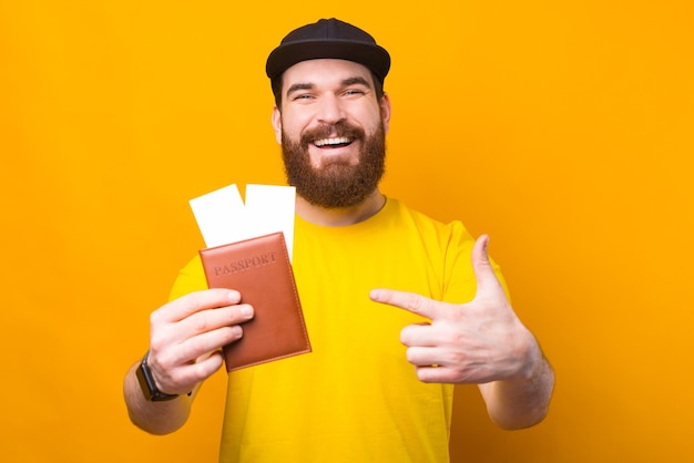 Happy traveller pointing at passport with airplane tickets, lets go travel