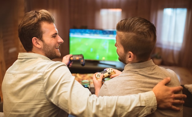 The happy two friends play the console