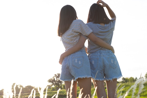 happy two young girl at meadow beautiful nature background.