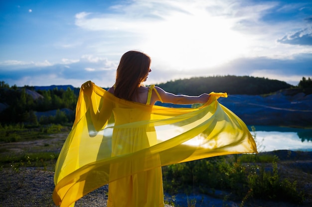 Happy ukrainian woman running in nature in a long yellow dress\
symbol of freedom of ukraine woman patriot of ukraine freedom peace\
without war selective focus