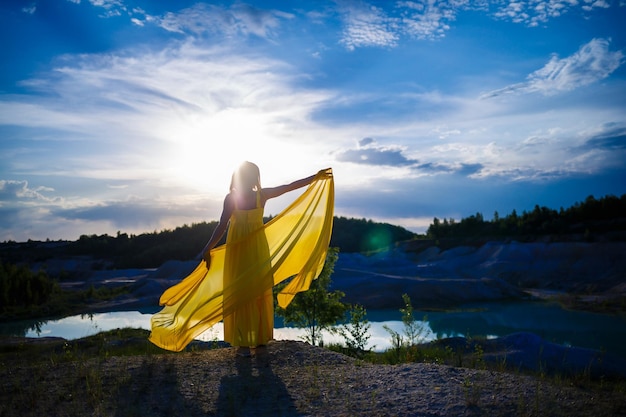 Happy ukrainian woman running in nature in a long yellow dress\
symbol of freedom of ukraine woman patriot of ukraine freedom peace\
without war selective focus