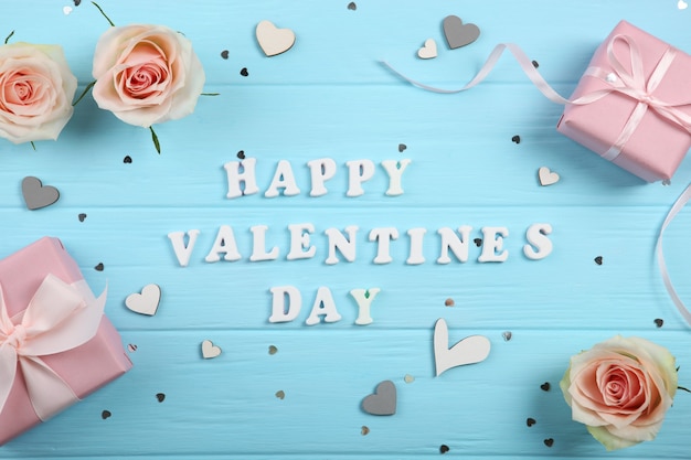 Happy Valentijnsdag tekst met geschenken en decoraties op blauwe achtergrond