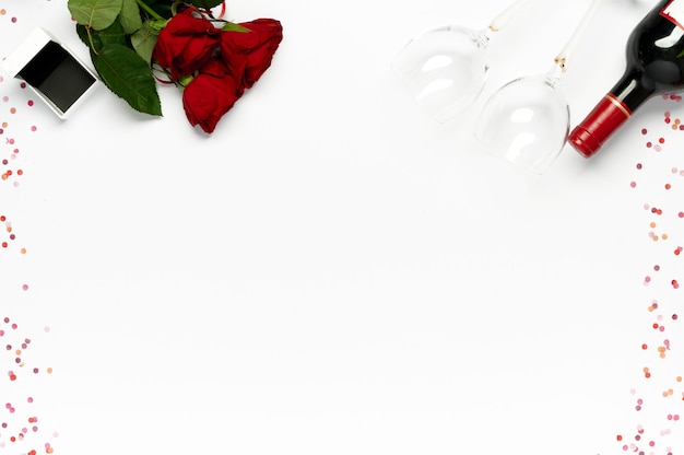 해피 발렌타인 데이. 반지, 와인 병 및 흰색 색종이와 안경 선물 상자와 빨간 장미의 무리