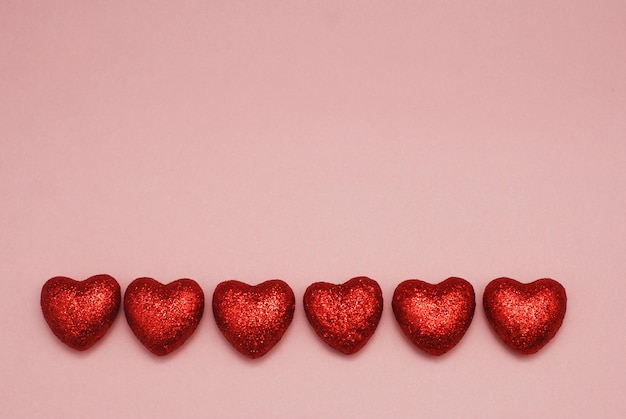 С Днем Святого Валентина праздничный блеск красных сердец на розовом фоне. Изоальтед. Шаблон приветствия дня святого Валентина с копией пространства.