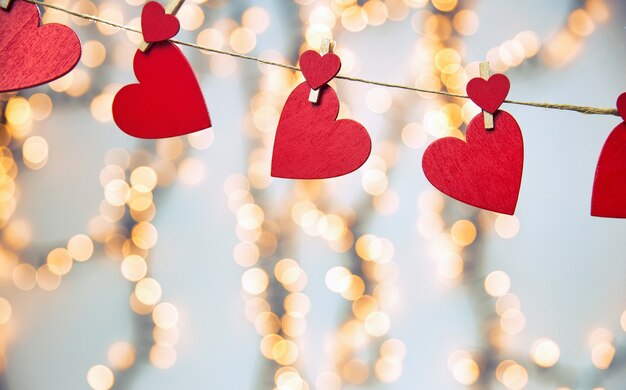 Happy Valentine day with red hearts hang with clothespins on rope and bokeh lights