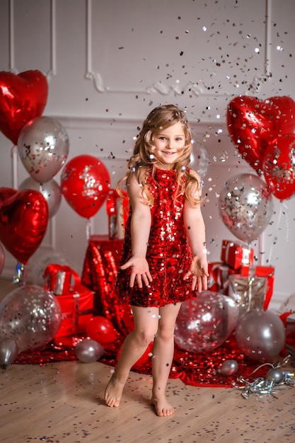 Happy Valentine's Day! cute girl in red dress with balloons and confetti