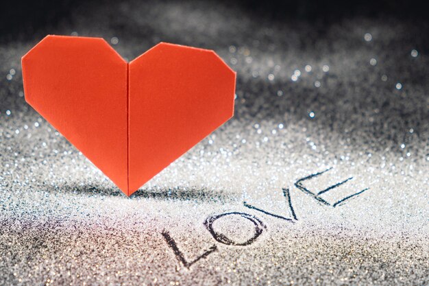 Photo happy valentine's day red heart on a black snowcovered shiny background text love