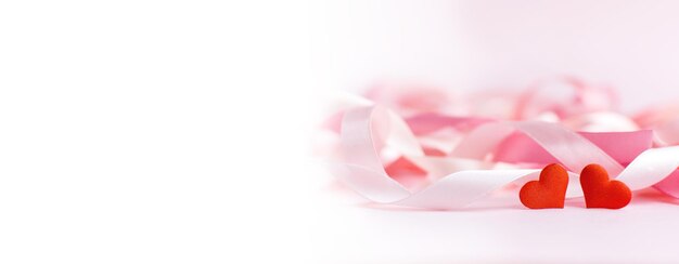 Photo happy valentine's day red hearts on background of blurred holiday ribbons banner