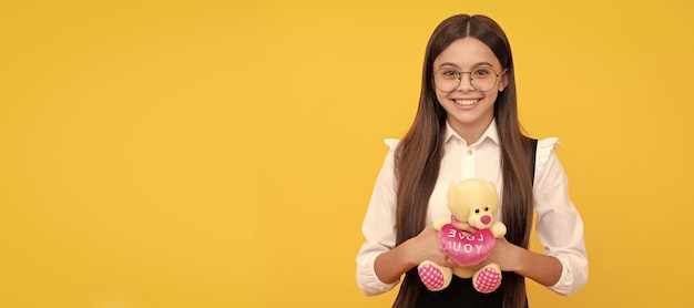 Happy valentines day school girl smile holding teddy bear love you valentines day february 14 school education banner of child girl with toy studio portrait header with copy space