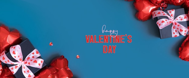 Happy Valentines Day tekst met geschenkdoos en rood hart vorm ballonnen op blauwe achtergrond Valentijnsdag wenskaart