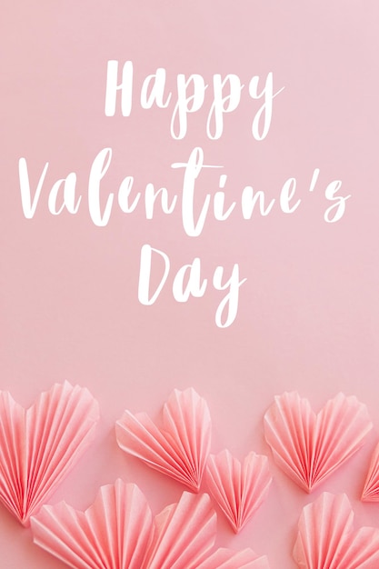 Happy valentines day text on cute pink hearts flat lay on pink paper background Modern Valentines day greeting card Handwritten sign Heart border