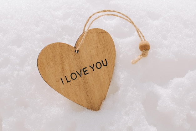 Happy Valentines Day Wooden heart with the words I love you in the snow