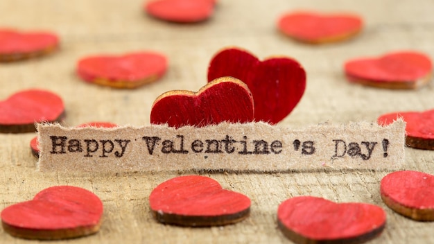Happy Valentines day zin getypt Valentijnsdag groeten concept Kleine rode houten hart close-up Valentines wenskaart