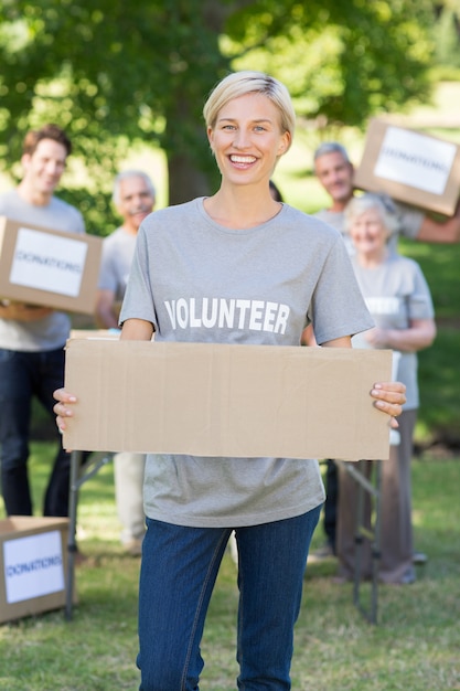 Photo happy volunteer blonde holding blank