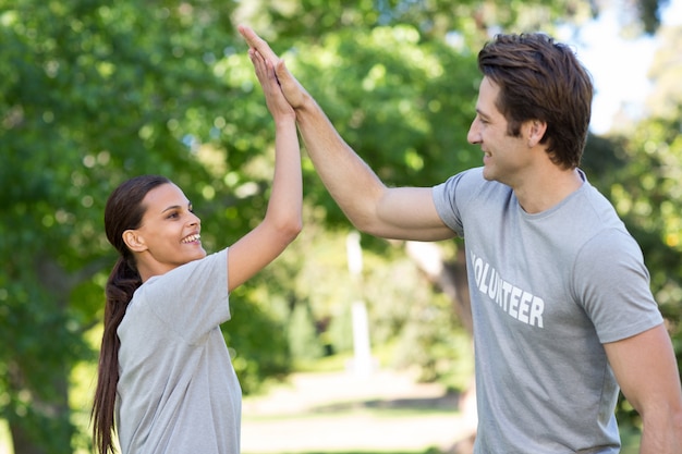 Happy volunteer couple high fiving 