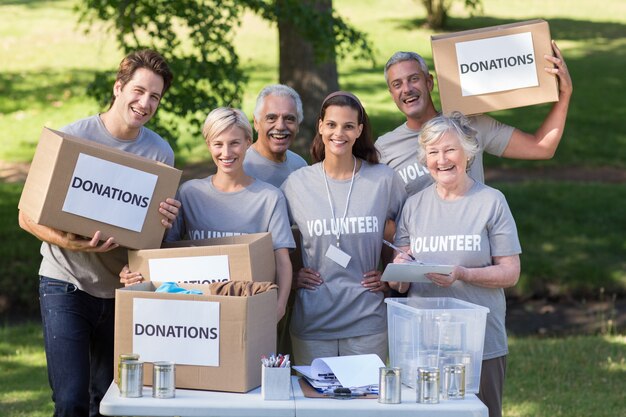 Happy volunteer family holding donations boxes 