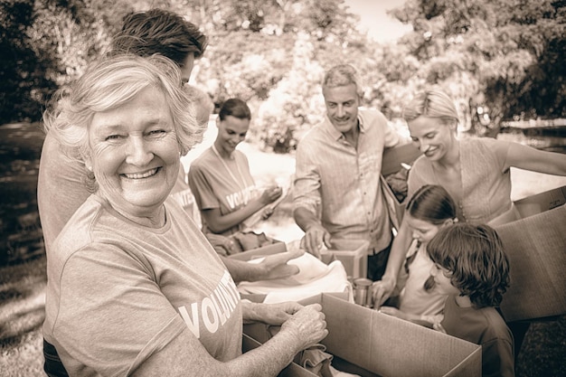 Photo happy volunteer family separating donations stuffs