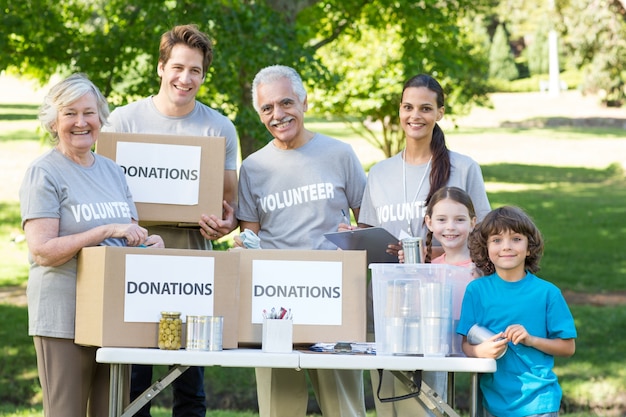 Photo happy volunteer family separating donations stuffs