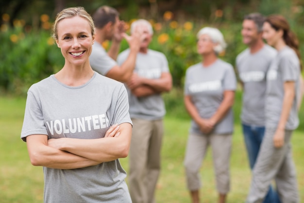 Happy volunteer looking at camera with arms crossed