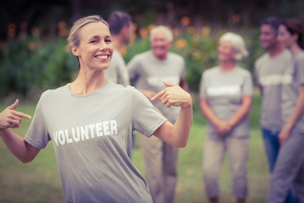 Happy volunteer showing her t-shirt to camera 