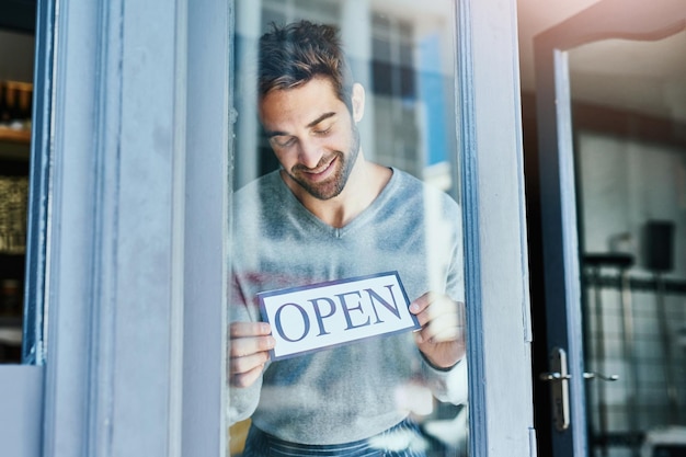 happy waiter and man at cafe with open sign for startup or small business and ownership coffee shop proud and happy or satisfied at restaurant door with welcome note for customer services